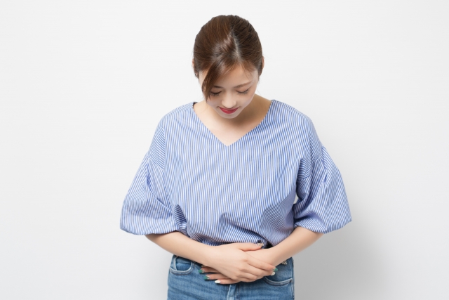 お腹を押さえる女性